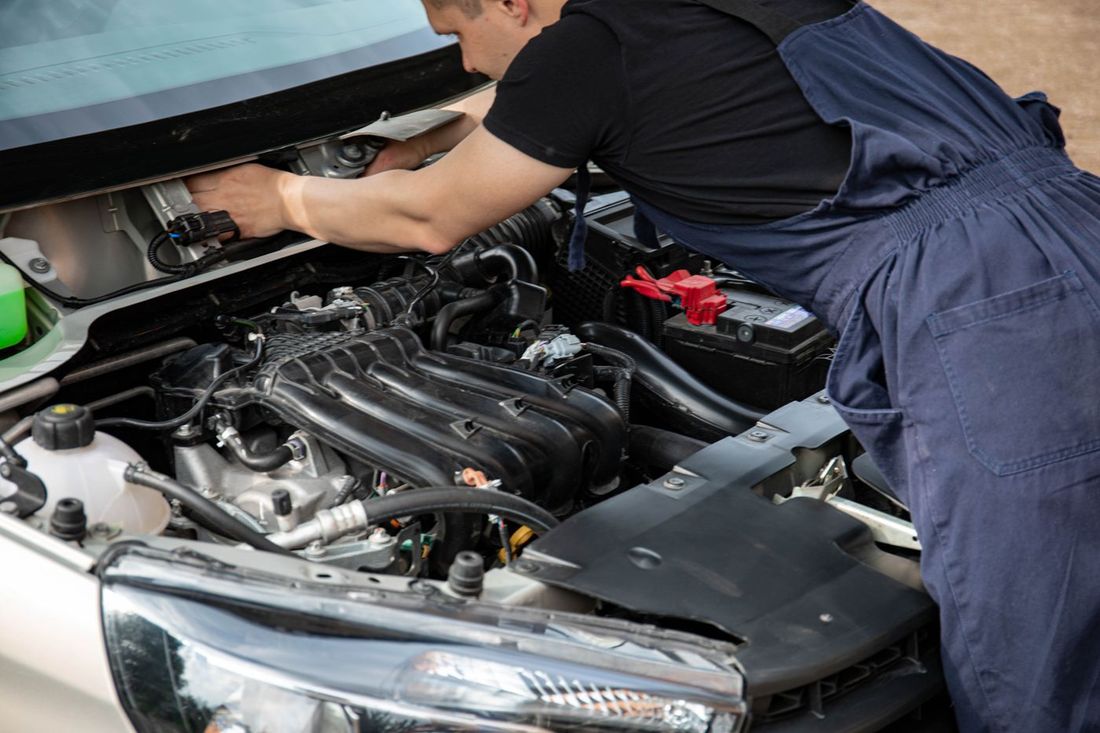 Mechaniker bei der Reparatur im Motorraum